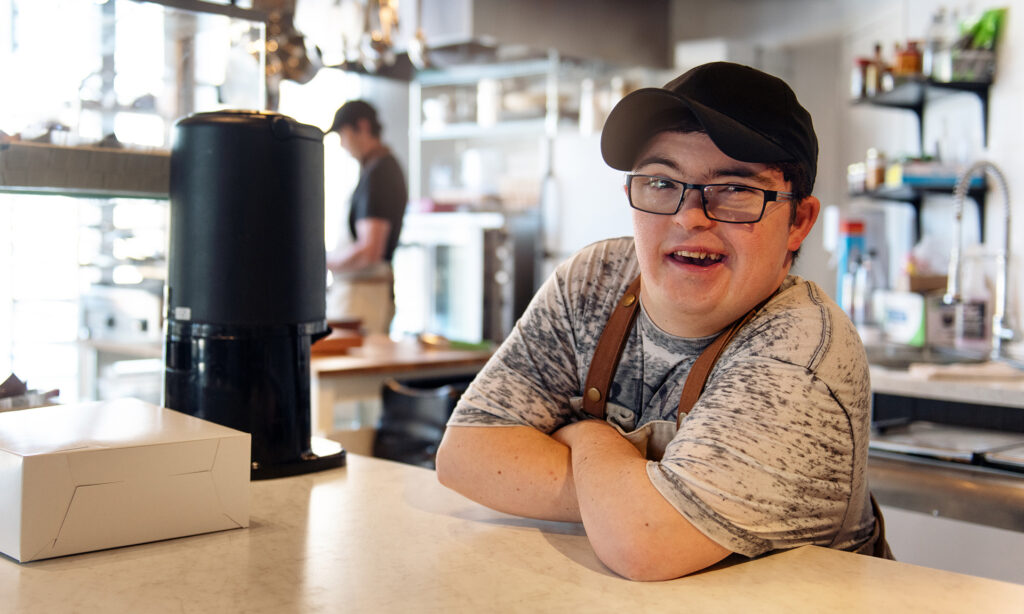 A young man with a disability working at a cafe