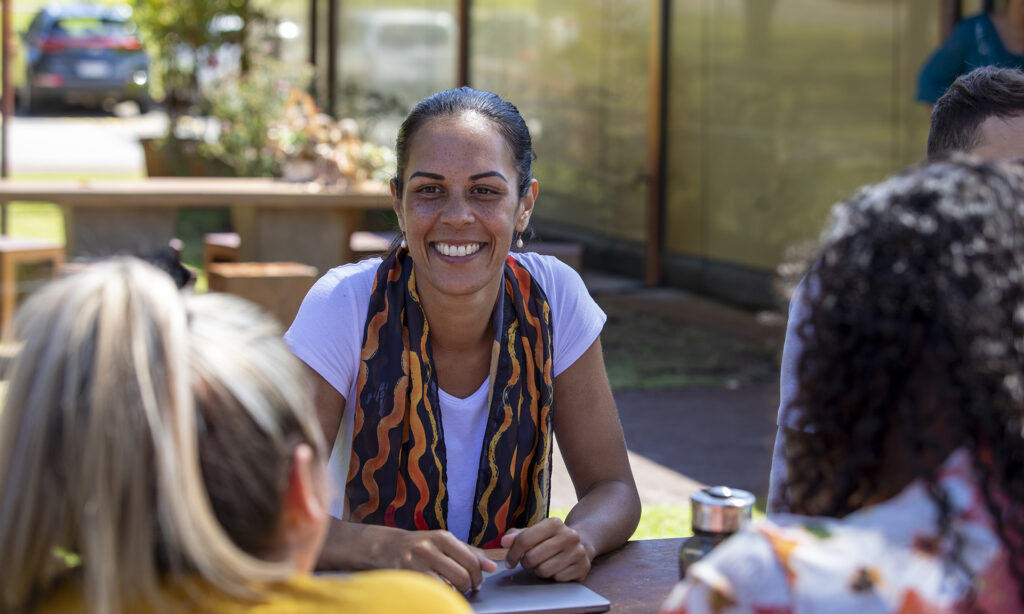 Close-up of young aboriginal students studying together outdoors in the sun in Australia.