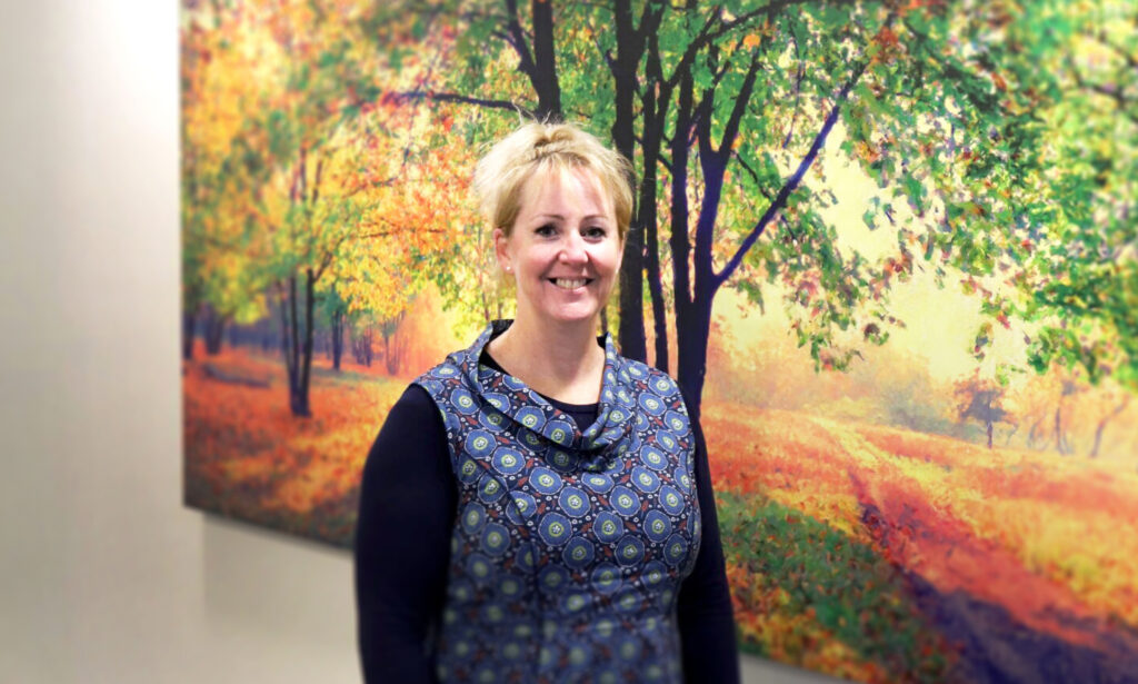 Portrait of Claire Conlon in front of a colourful painting