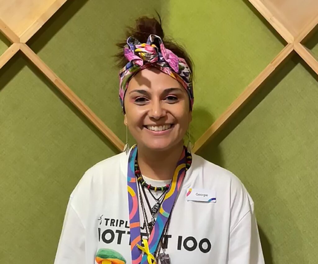 Portrait of Georgie Sawyer wearing a colourful bandana and lanyard