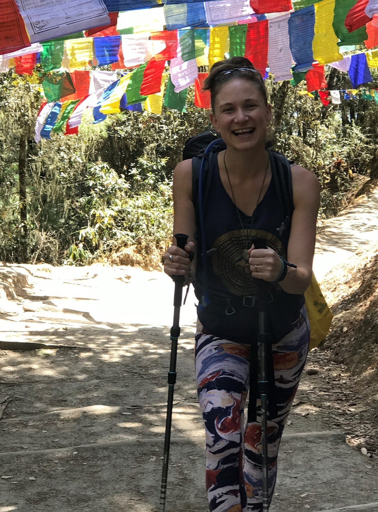 Jemma Podem Hiking a trail with colourful flags overhead