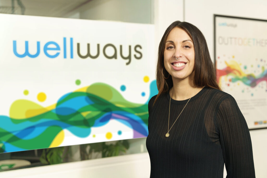 Portrait of Rachael Rodier in front of Wellways sign