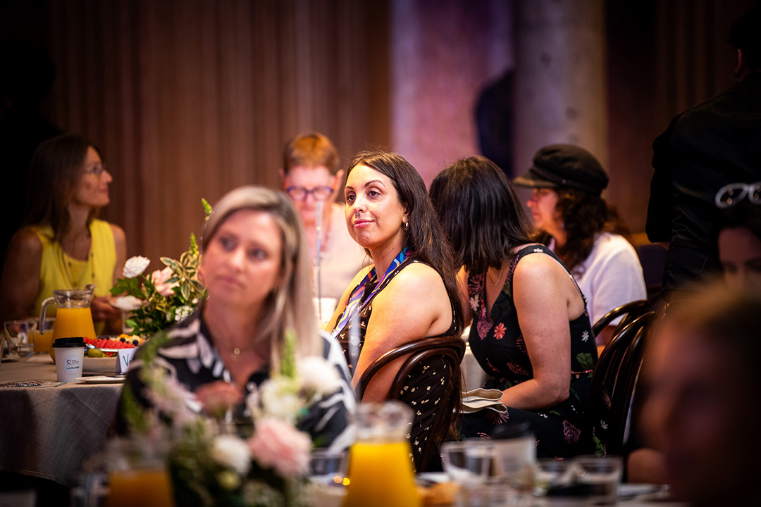 Several people sitting at a table with food and drink.