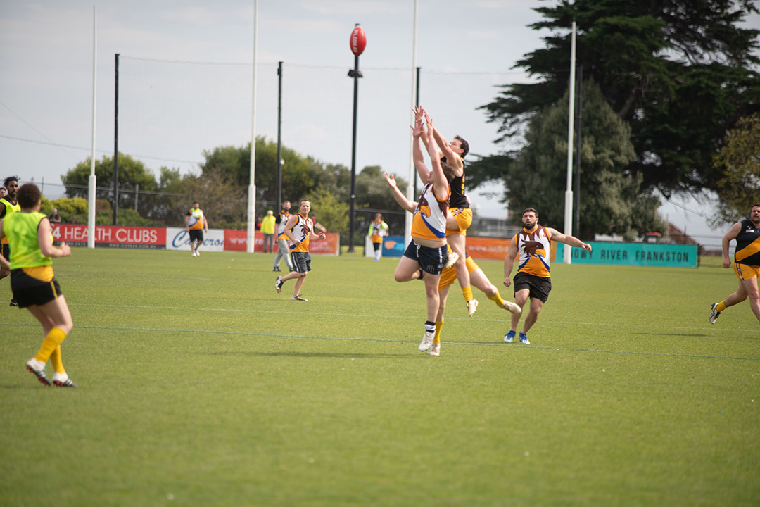 Footballers on the field jumping for the ball